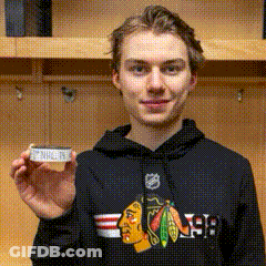 A Young Man Wearing A Black Chicago Blackhawks Hoodie Is Holding A Piece Of Paper GIF