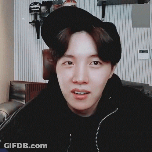 A Young Man Wearing A Black Hat And A Black Jacket Looks At The Camera GIF