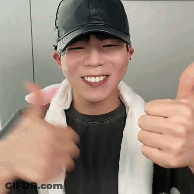 A Young Man Wearing A Black Hat Is Giving A Thumbs Up Sign GIF