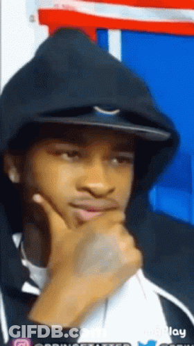A Young Man Wearing A Black Hoodie And A Hat Is Thinking . GIF
