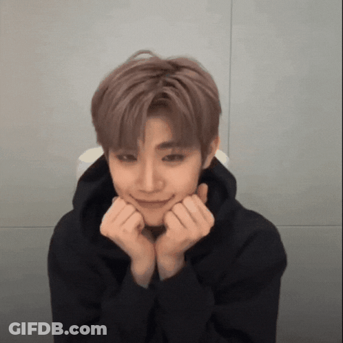 A Young Man Wearing A Black Hoodie Is Making A Face With His Hands On His Chin . GIF