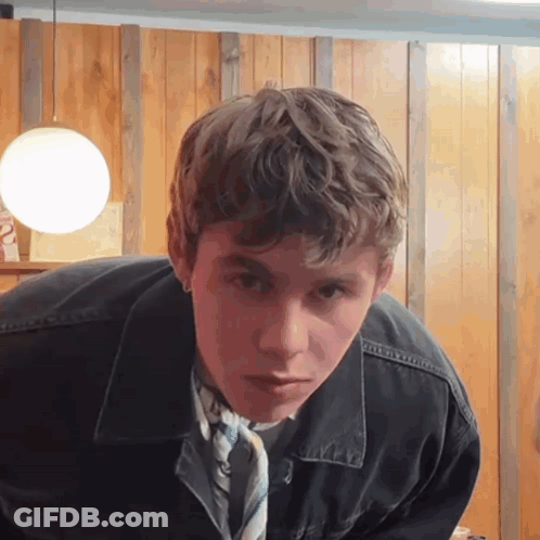 A Young Man Wearing A Black Jacket And A Tie GIF