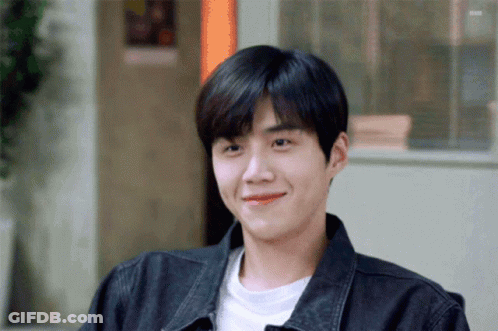 A Young Man Wearing A Black Jacket And A White Shirt Smiles For The Camera GIF