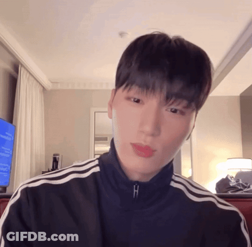 A Young Man Wearing A Black Jacket With White Stripes On The Sleeves GIF