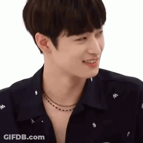 A Young Man Wearing A Black Shirt And A Necklace With The Letter W On It GIF