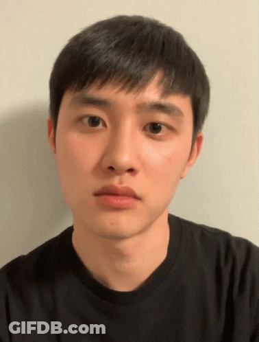 A Young Man Wearing A Black Shirt Looks At The Camera With A Serious Look On His Face GIF