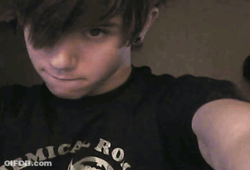 A Young Man Wearing A Black Shirt That Says ' Erica Rock ' On It GIF