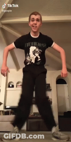 A Young Man Wearing A Black Shirt That Says Nirvana GIF