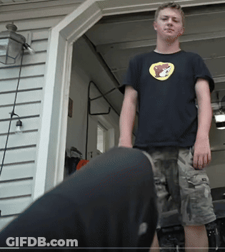 A Young Man Wearing A Black Shirt With A Yellow Bear On It GIF