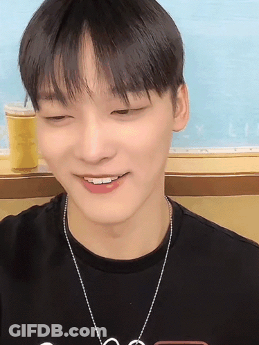 A Young Man Wearing A Black T-Shirt And A Necklace With The Letter S On It GIF