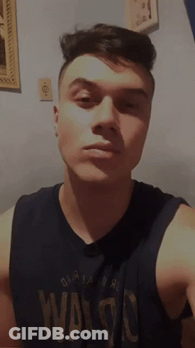 A Young Man Wearing A Black Tank Top That Says Waldo GIF