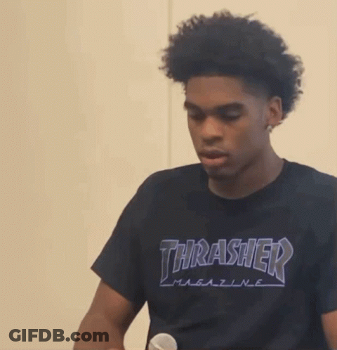 A Young Man Wearing A Black Thrasher T-Shirt Is Holding A Microphone GIF
