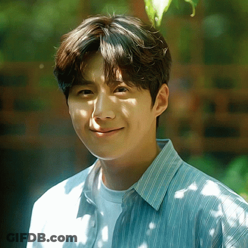 A Young Man Wearing A Blue And White Striped Shirt Is Smiling GIF