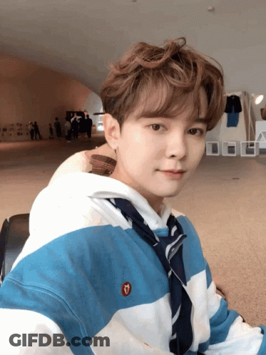A Young Man Wearing A Blue And White Striped Shirt With A Heart Embroidered On It GIF