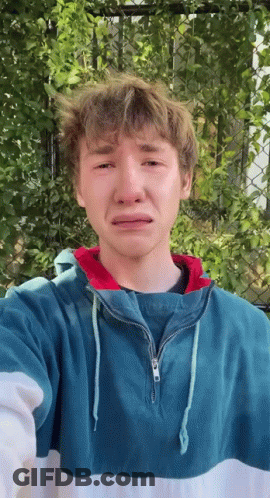 A Young Man Wearing A Blue And White Striped Sweatshirt Is Crying . GIF