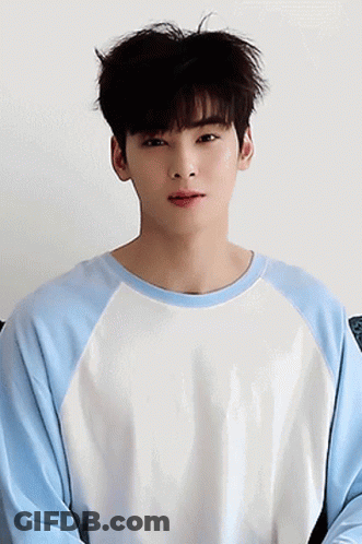 A Young Man Wearing A Blue And White Sweater Looks At The Camera GIF