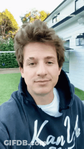 A Young Man Wearing A Blue Kanji Hoodie Takes A Selfie GIF