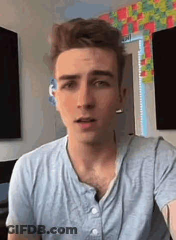 A Young Man Wearing A Blue Shirt Is Looking At The Camera . GIF