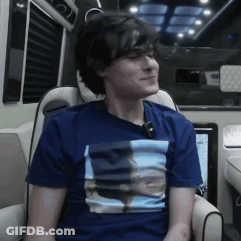 A Young Man Wearing A Blue Shirt With A Picture Of A Man On It GIF