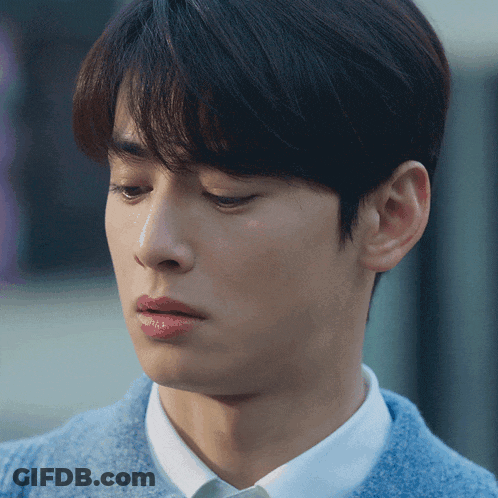 A Young Man Wearing A Blue Sweater And White Shirt GIF