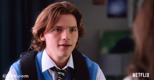 A Young Man Wearing A Blue Vest And Tie With A Netflix Logo On The Bottom GIF