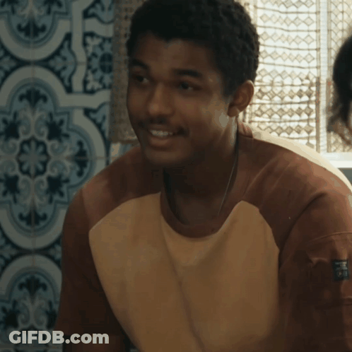 A Young Man Wearing A Brown And White Shirt With The Word Puma On The Arm GIF