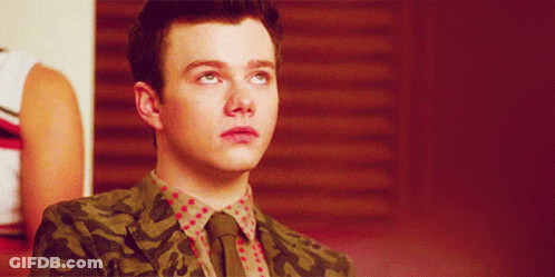 A Young Man Wearing A Camouflage Jacket And Tie GIF