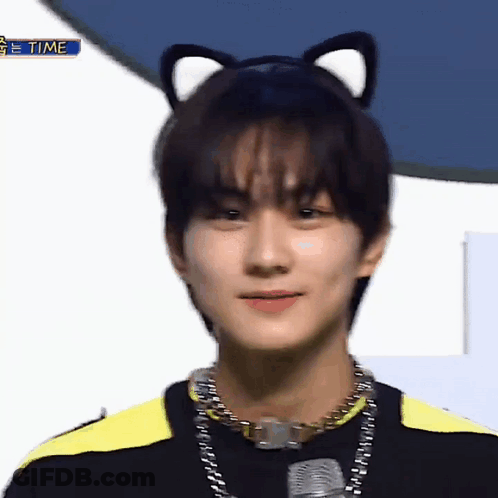 A Young Man Wearing A Cat Ear Headband And A Necklace Is Looking At The Camera . GIF