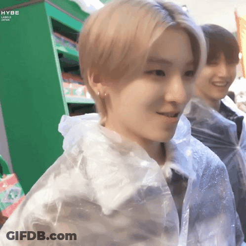 A Young Man Wearing A Clear Plastic Raincoat Is Smiling GIF