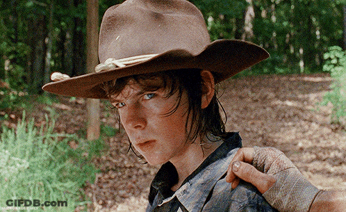 A Young Man Wearing A Cowboy Hat Is Being Held By Another Person 'S Hand GIF