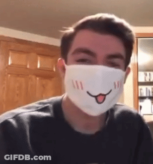 A Young Man Wearing A Face Mask With A Smiling Face On It GIF