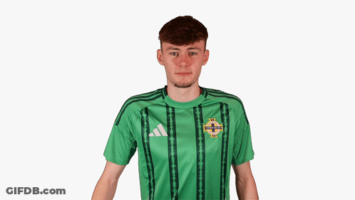 A Young Man Wearing A Green Adidas Shirt Covering His Ears GIF