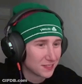 A Young Man Wearing A Green Beanie And Headphones Is Smiling . GIF