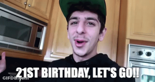 A Young Man Wearing A Green Hat Is Standing In Front Of A Microwave In A Kitchen . GIF