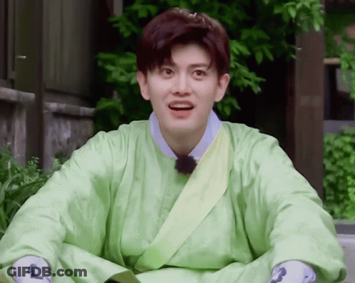 A Young Man Wearing A Green Robe With A Yellow Sash Around His Waist GIF