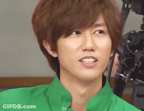 A Young Man Wearing A Green Shirt Is Smiling For The Camera GIF