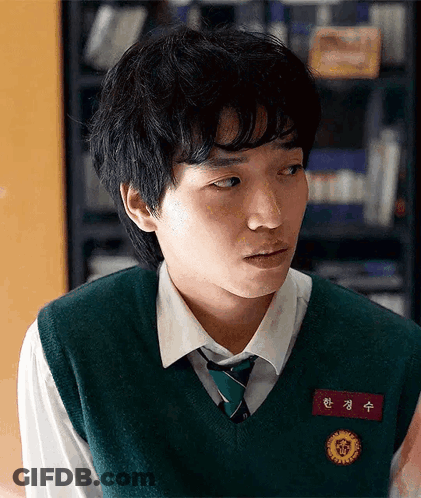 A Young Man Wearing A Green Vest And Tie Has A Name Tag With Chinese Characters GIF