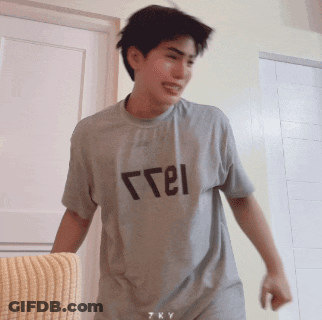 A Young Man Wearing A Grey T-Shirt That Says " Free " On It GIF