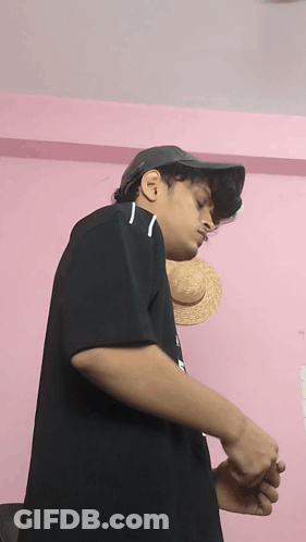 A Young Man Wearing A Hat And A Black Shirt With The Letter N On It GIF