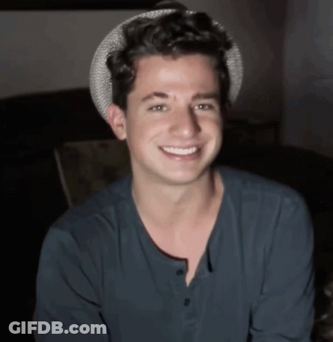 A Young Man Wearing A Hat And A Blue Shirt Is Smiling GIF