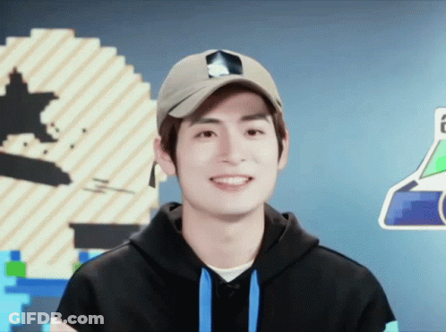 A Young Man Wearing A Hat And A Hoodie Smiles For The Camera GIF
