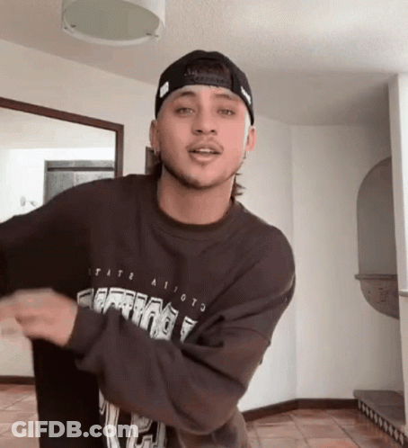 A Young Man Wearing A Hat And A Sweatshirt That Says Tate GIF