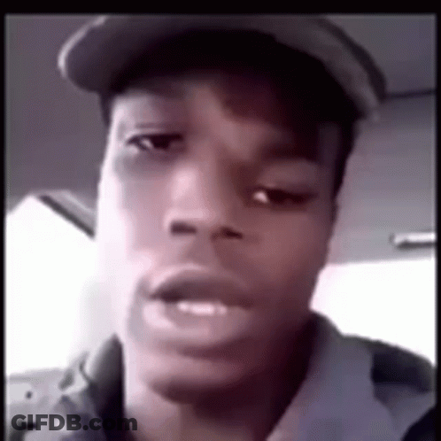 A Young Man Wearing A Hat Is Looking At The Camera . GIF