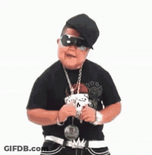 A Young Man Wearing A Hat , Sunglasses And A Chain Around His Neck Is Standing In Front Of A White Background . GIF