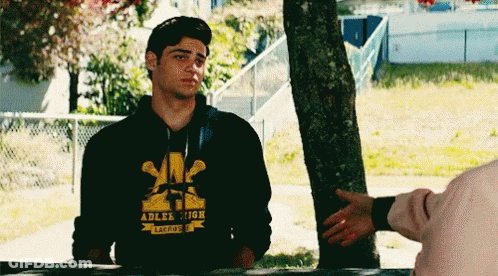 A Young Man Wearing A Hoodie That Says Adler High Is Shaking Hands With Another Person . GIF