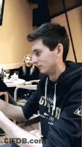 A Young Man Wearing A Hoodie That Says Gsta Is Sitting At A Table GIF