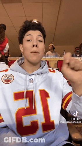 A Young Man Wearing A Hoodie With The Number 12 On It GIF