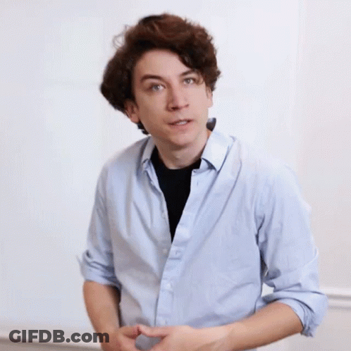 A Young Man Wearing A Light Blue Shirt And A Black Shirt GIF