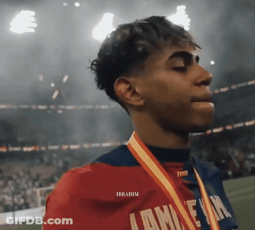 A Young Man Wearing A Medal Around His Neck With The Name Ibrahim On The Bottom GIF