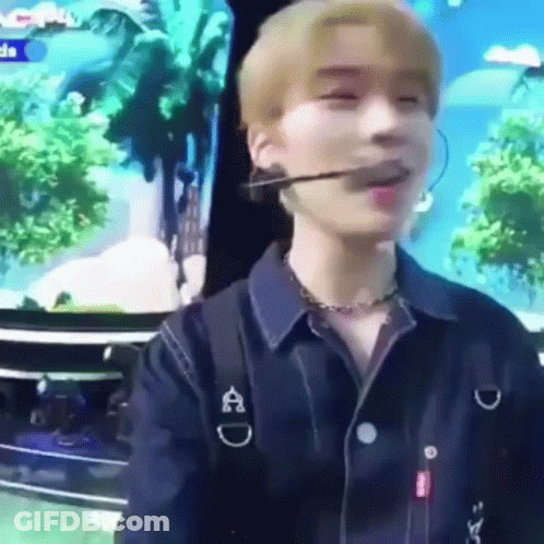 A Young Man Wearing A Microphone And A Necklace Is Sitting In Front Of A TV . GIF
